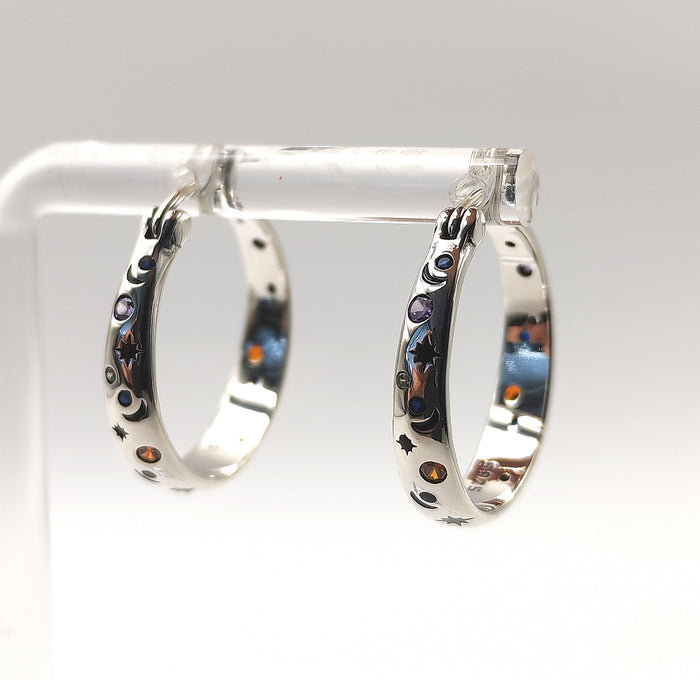 Side view of sterling silver hoop earrings with celestial moon and star engravings