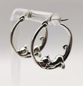 Side-angle photo showing the curved hoop and detailed curled-tail sleeping cat charm in sterling silver.