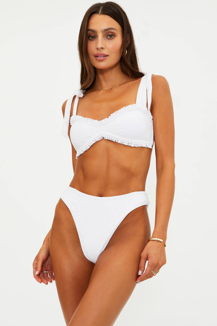 Woman wearing a white high cut swim bottoms with pointelle knit fabric.