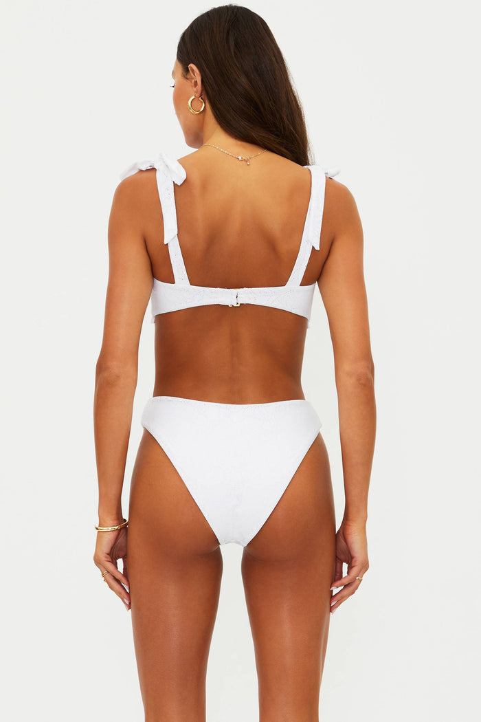 Woman wearing a white bikini with a plain background