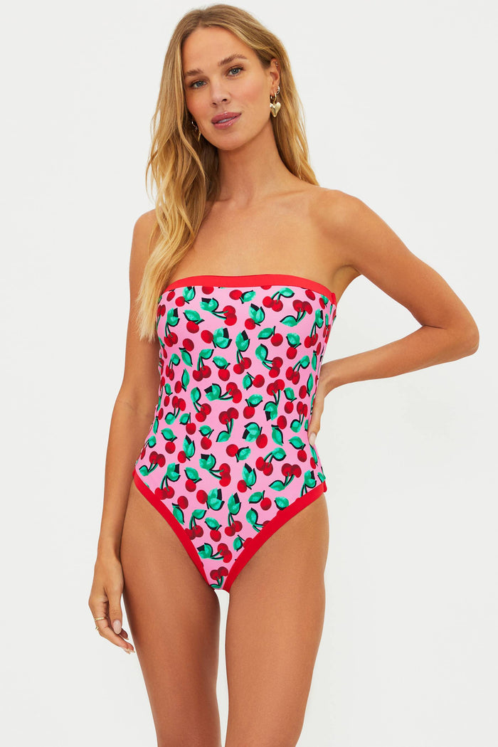 Woman wearing a strapless one piece with pink and red cherries.