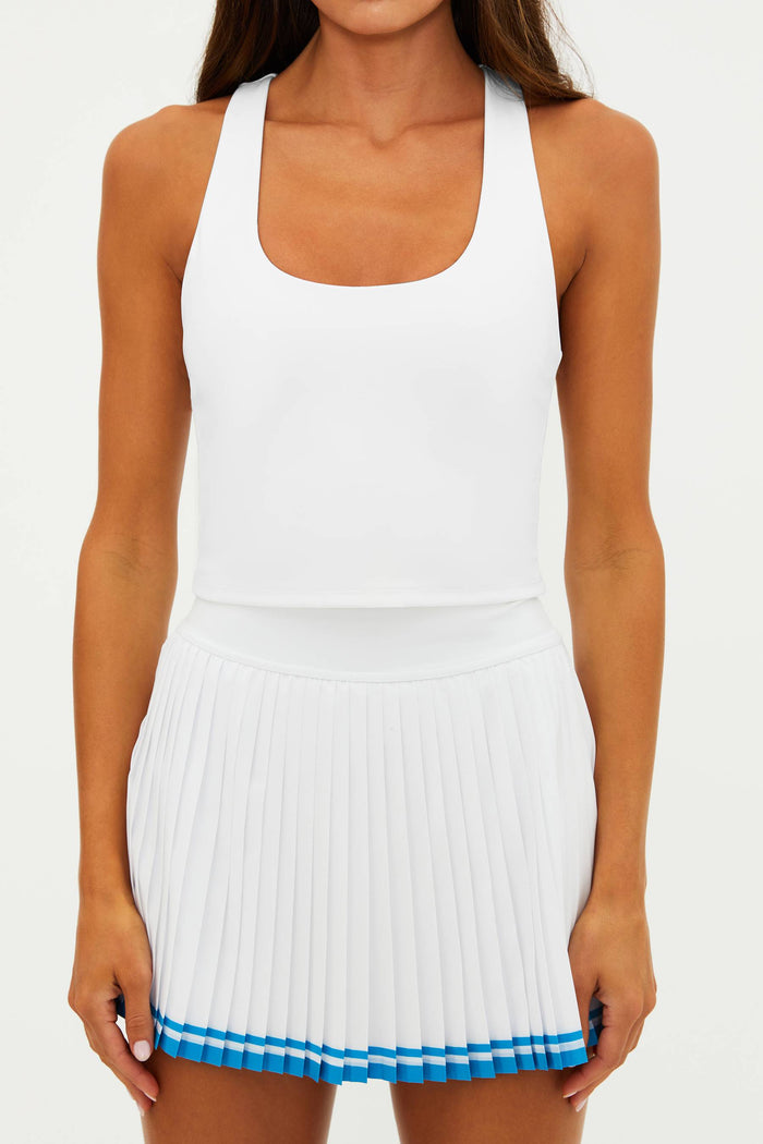 White pleated dress with blue trim worn by a person on a white background