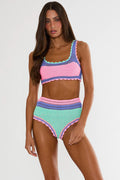Woman wearing a colorful crochet bikini set on a white background