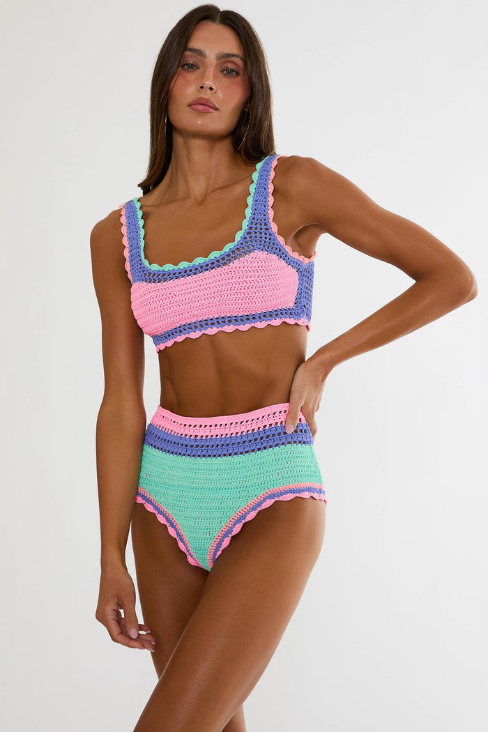 Woman wearing a colorful crochet bikini set on a white background
