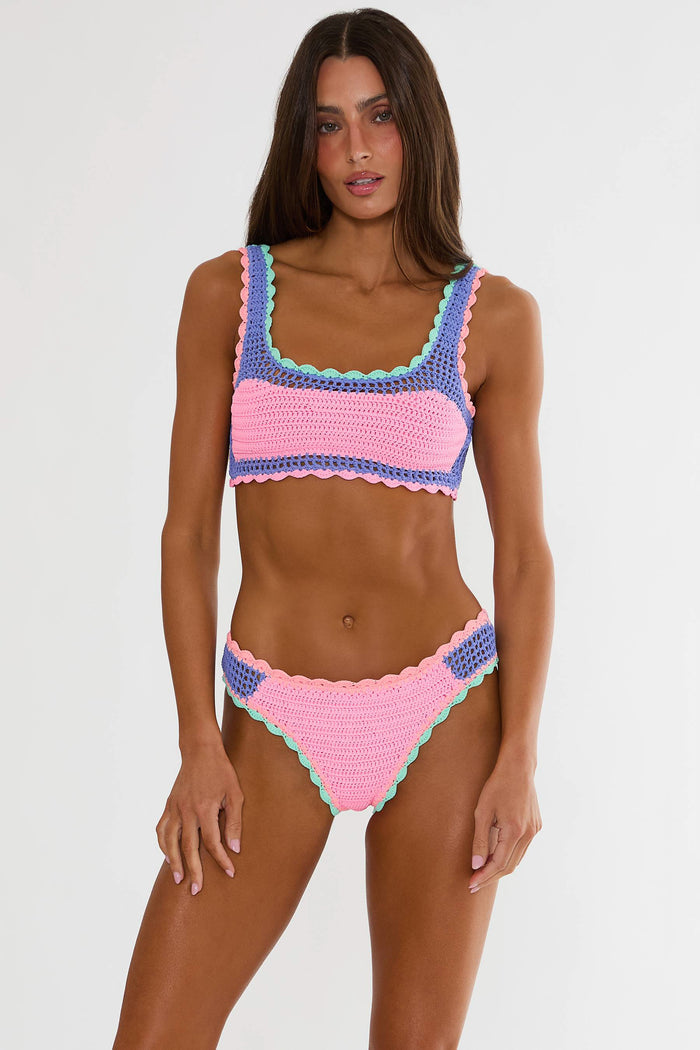 Woman wearing a colorful crochet bikini against a white background