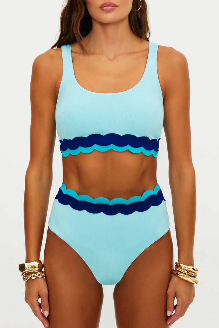 Woman wearing a blue and navy striped swimsuit on a white background