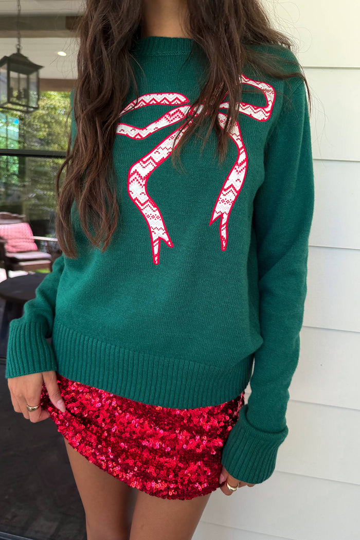 green sweater with red bow detail