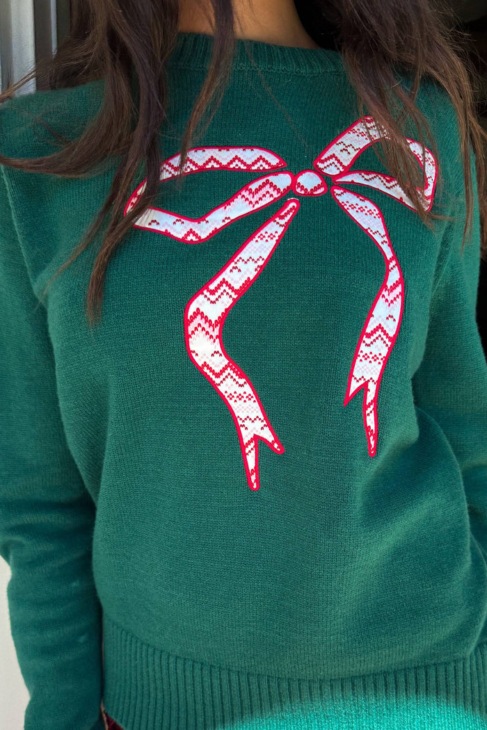 green sweater with red bow detail