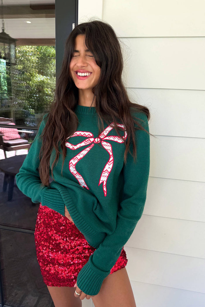 green sweater with red bow detail