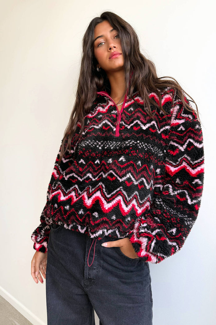 Person wearing a patterned sweater with a plain background