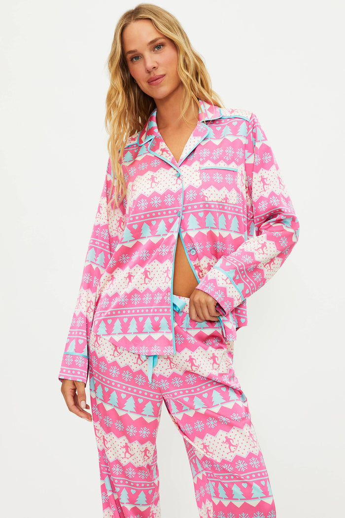 Woman wearing a pink patterned pajama set on a white background