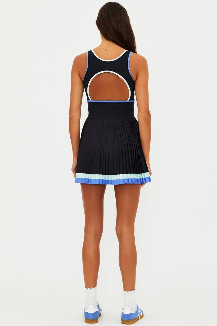 Woman wearing a black and blue dress with cut-out design on a white background