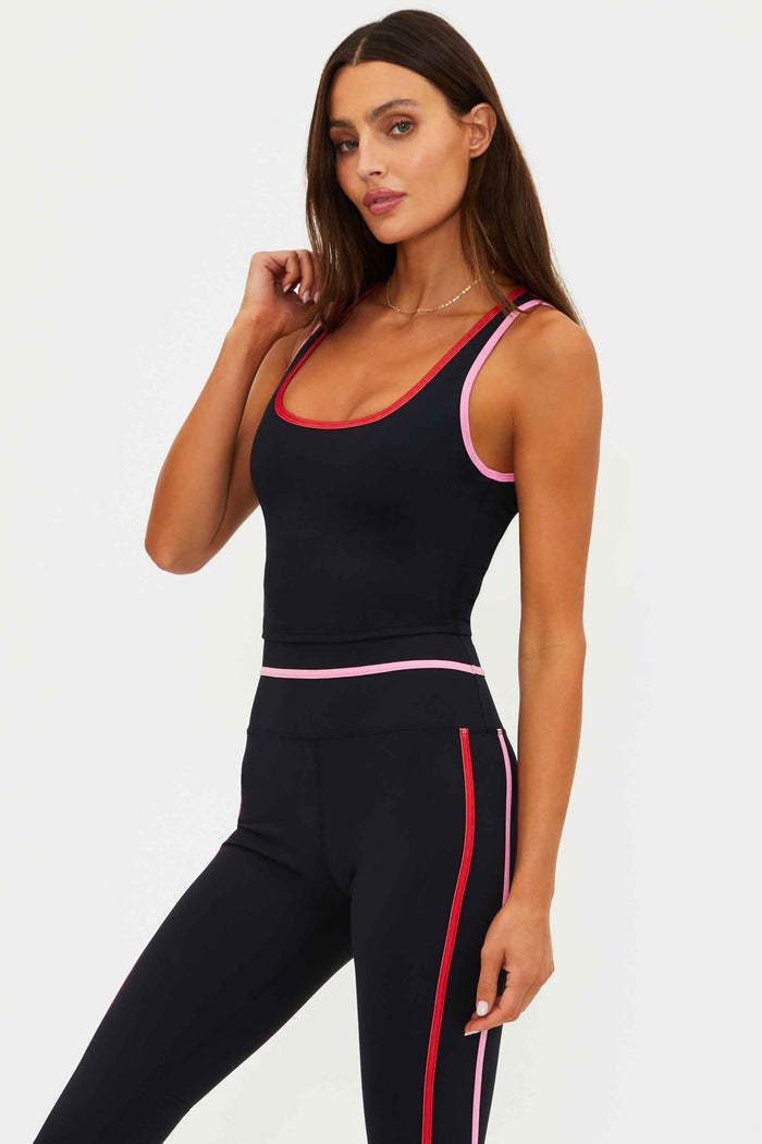 Woman wearing a black top with red and pink lining.