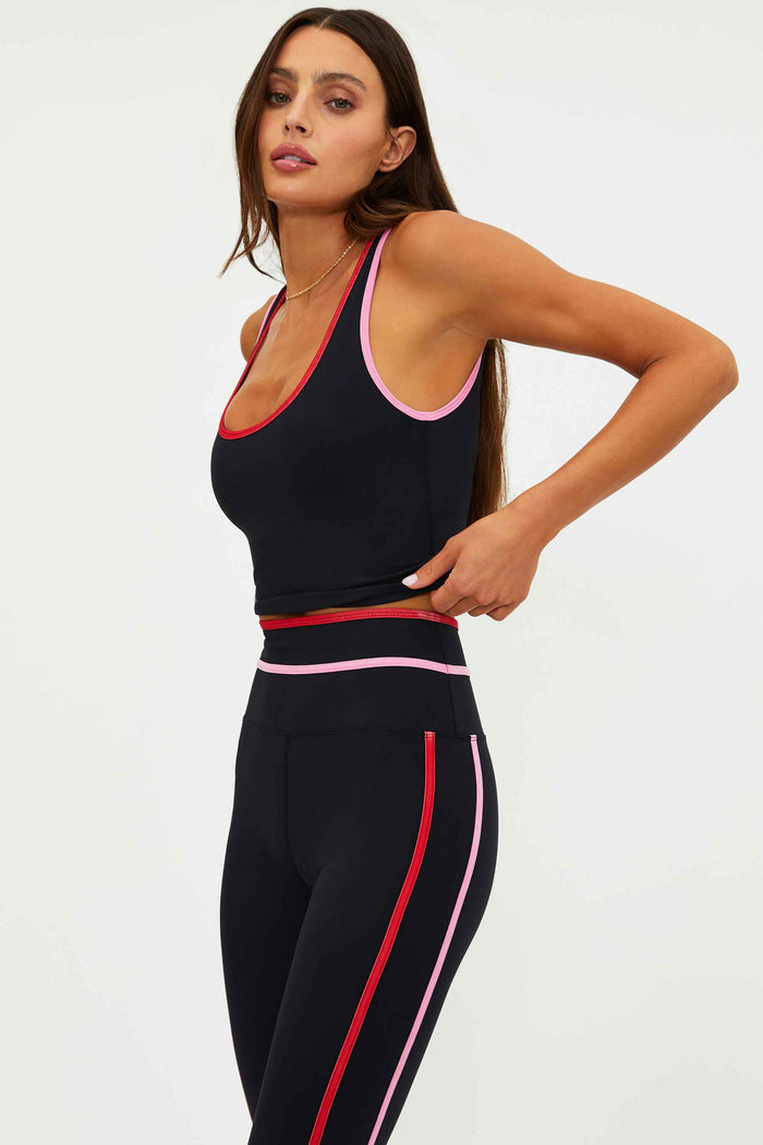 Woman wearing a black top with red and pink lining.