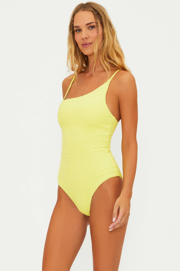 A model wearing a yellow one-piece swimsuit with adjustable straps and a shelf bra.