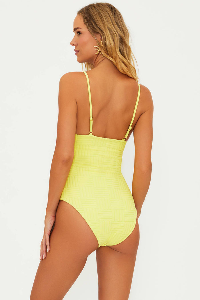 A model wearing a yellow one-piece swimsuit with adjustable straps and a shelf bra.