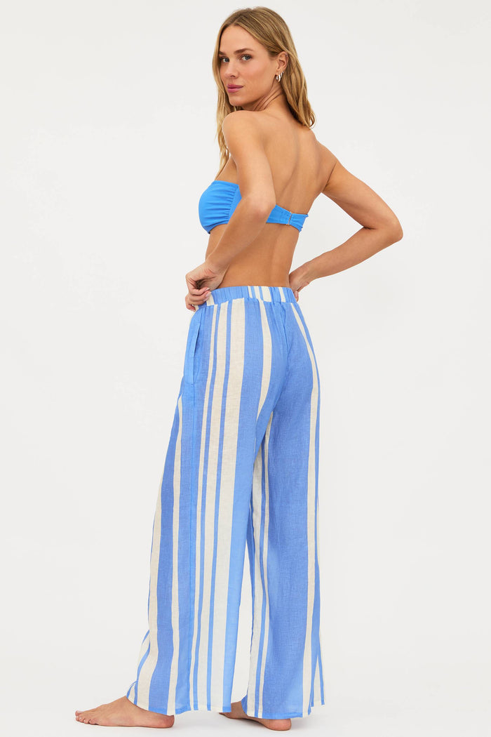 Woman wearing a blue and white striped wide-leg pants with a matching top on a white background