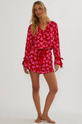 Woman wearing red and pink silk, shot and longsleeve pjs.