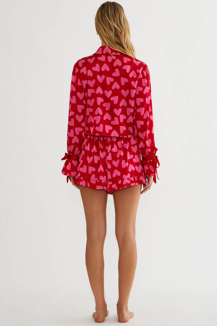 Woman wearing red and pink silk, shot and longsleeve pjs.