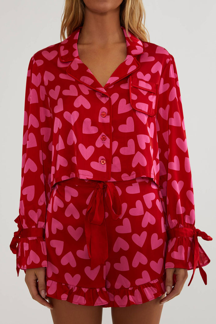Woman wearing red and pink silk, shot and longsleeve pjs.