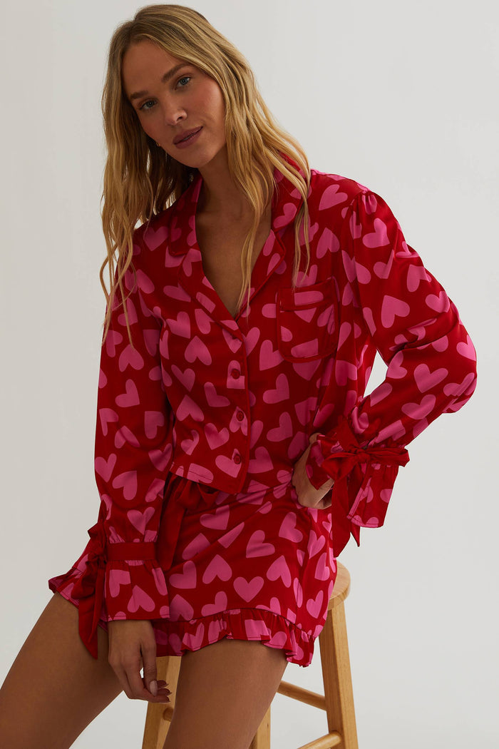 Woman wearing red and pink silk, shot and longsleeve pjs.