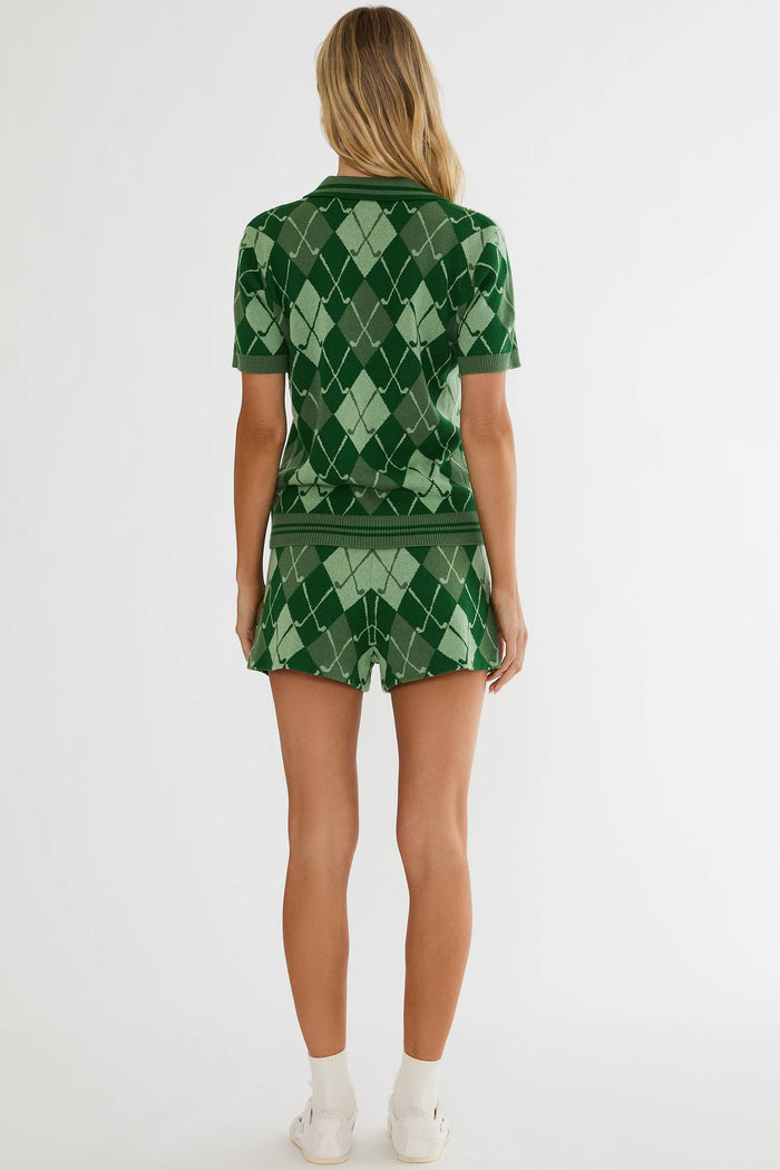 Person wearing a green argyle patterned outfit on a white background