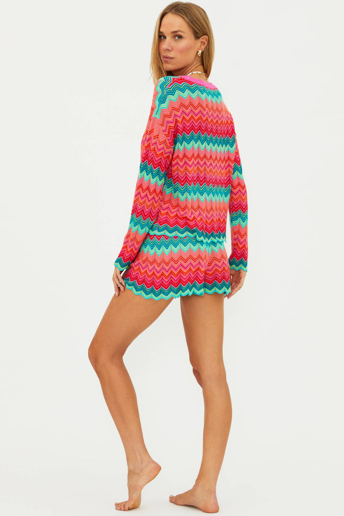 Woman wearing a colorful striped sweater dress on a white background