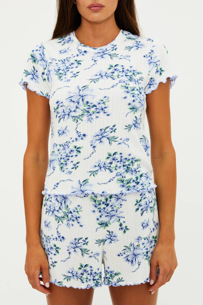White outfit with blue floral pattern worn by a person on a white background