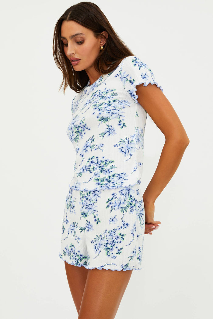 Woman wearing a white floral dress on a plain background