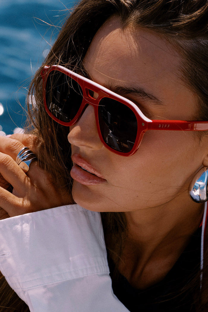 Woman wearing red sunglasses with a blurred background