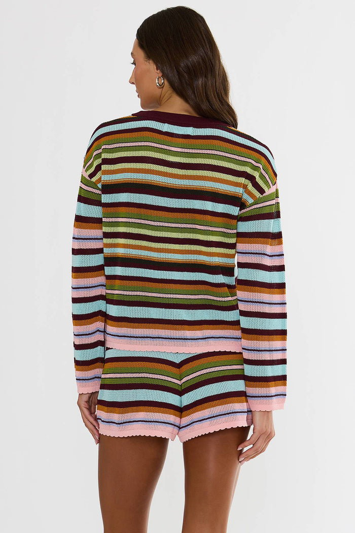 A woman modeling a matching striped knit long-sleeve top and shorts set. The set features horizontal stripes in pink, light blue, olive green, mustard yellow, brown, and dark burgundy, with a solid dark burgundy crew neck and drawstring waist.