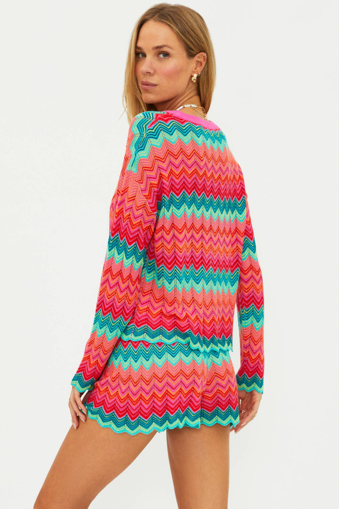 Woman wearing a colorful zigzag patterned dress on a white background