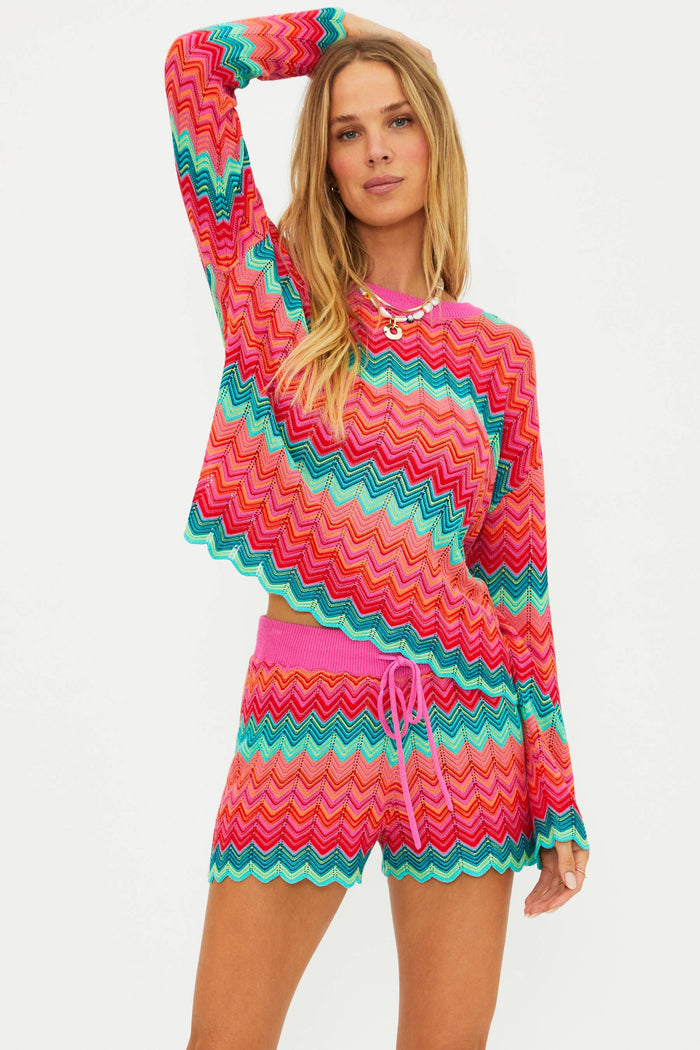 Woman wearing a colorful chevron patterned outfit on a white background