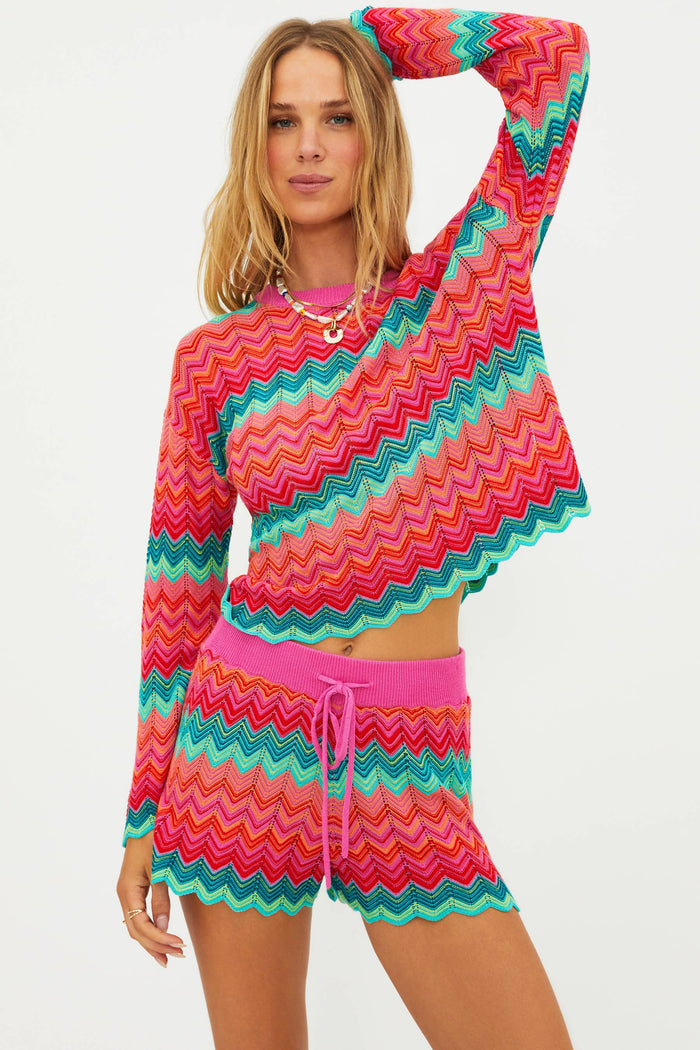 Woman wearing a colorful zigzag pattern outfit on a white background