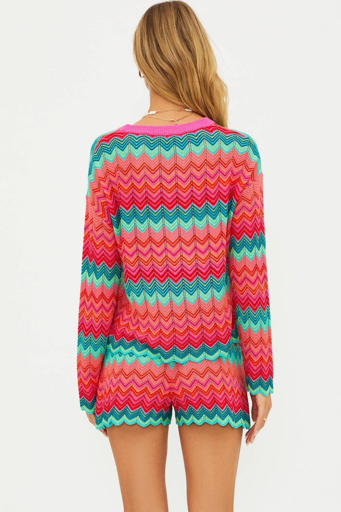 Woman wearing a colorful zigzag patterned outfit on a white background