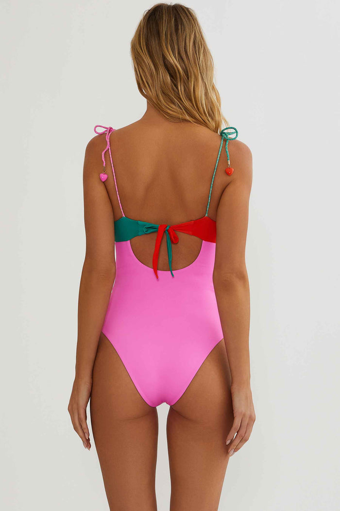Pink swimsuit with colorful straps on a white background
