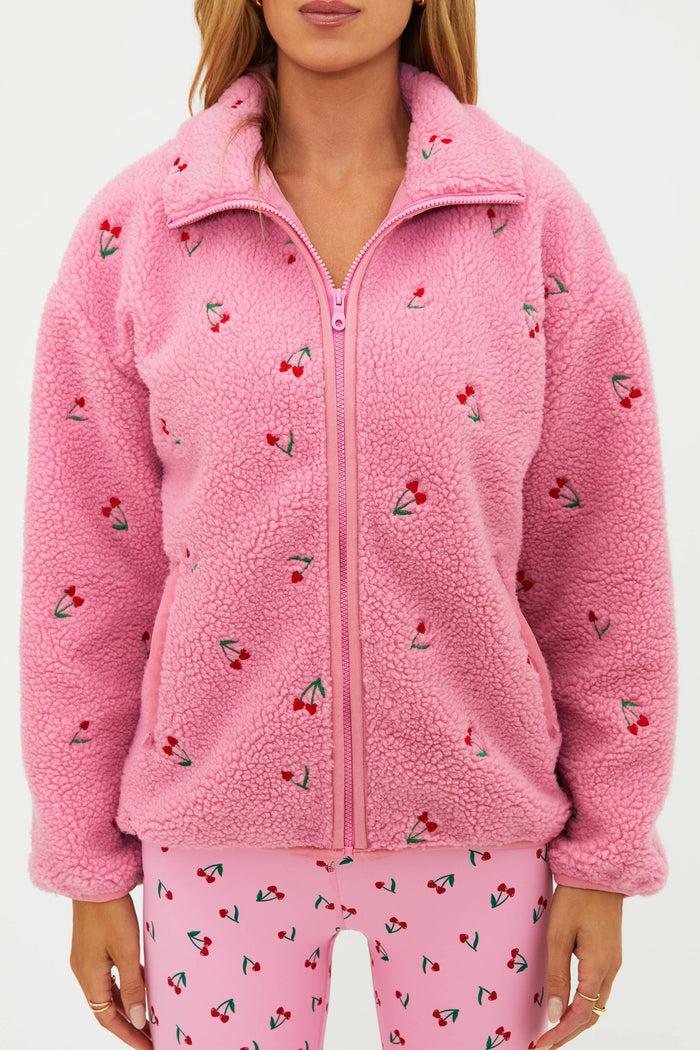 Pink sherpa with red cherries on it.
