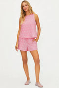 Woman wearing a pink polka dot pajama set on a white background