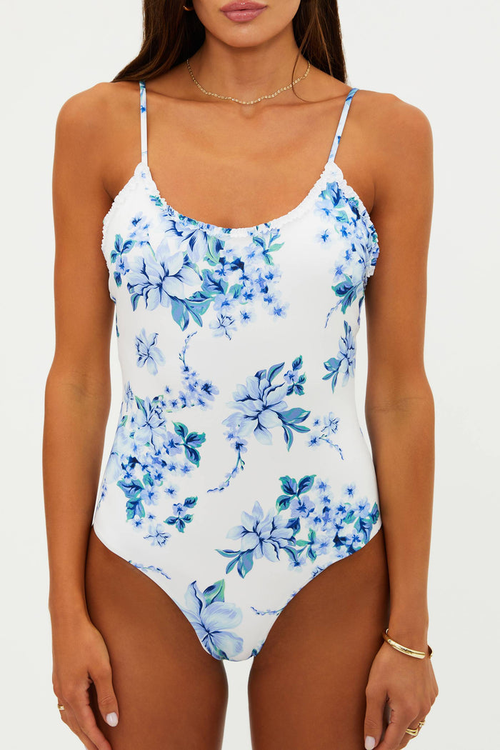Woman wearing a blue floral one-piece swimsuit on a white background