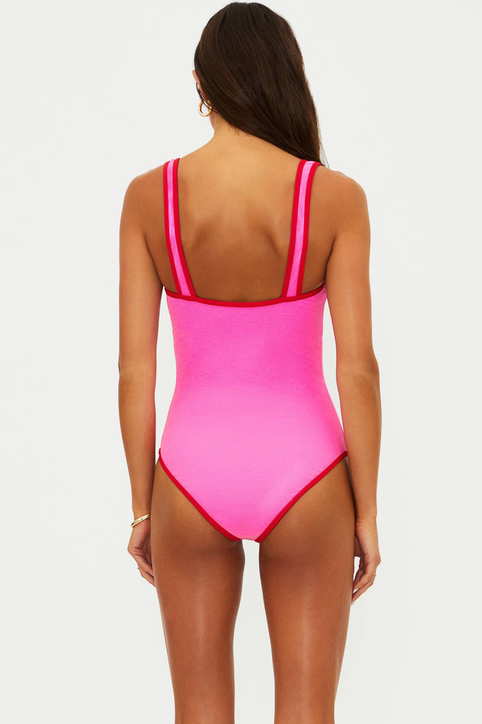 Woman wearing a bright pink swimsuit with thin straps on a white background