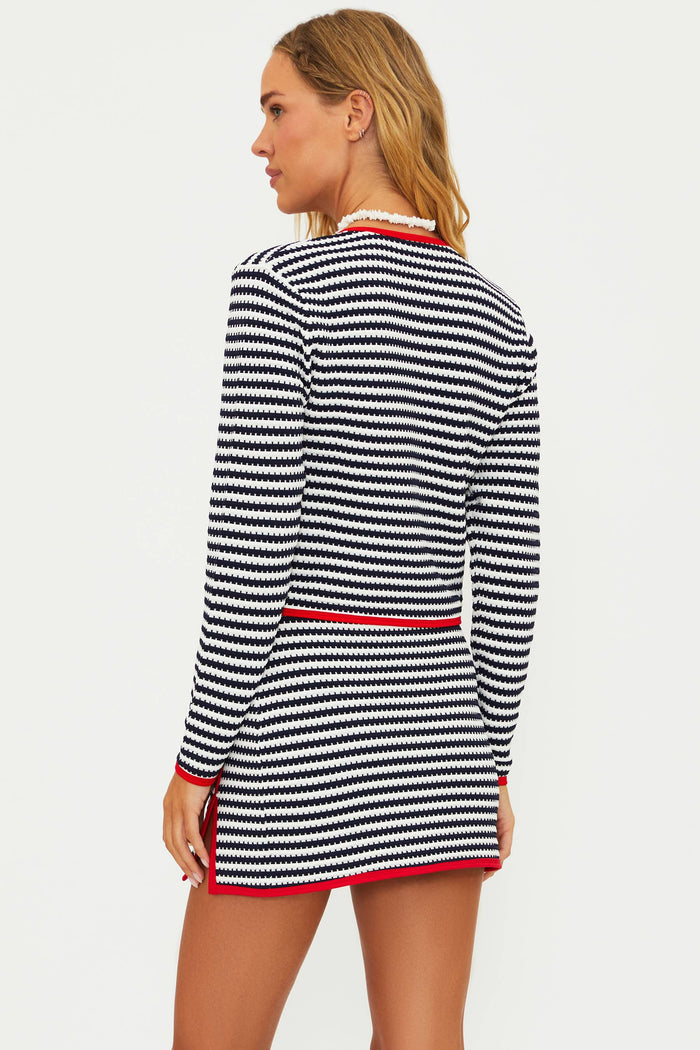 A female model wearing a striped cover-up with a cardigan-style top and red contrast trim.