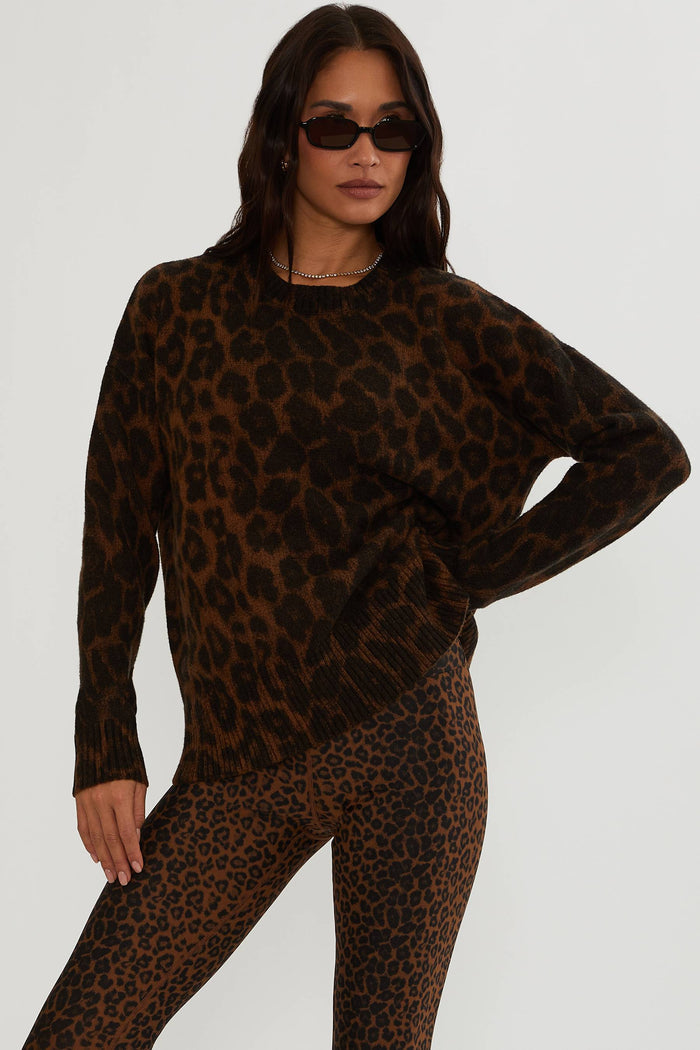 Woman wearing brown and black leopard sweater.