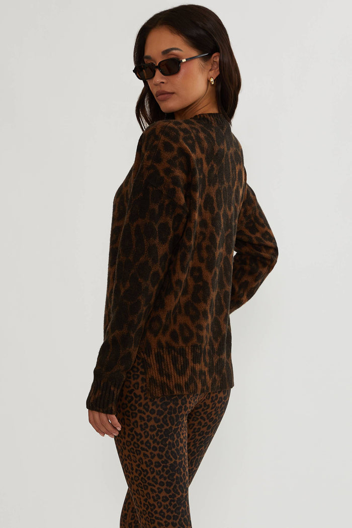 Woman wearing brown and black leopard sweater.