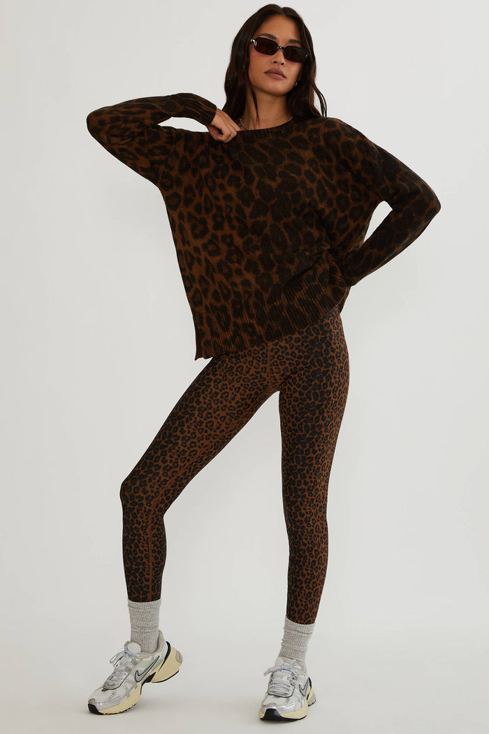 Woman wearing brown and black leopard sweater.