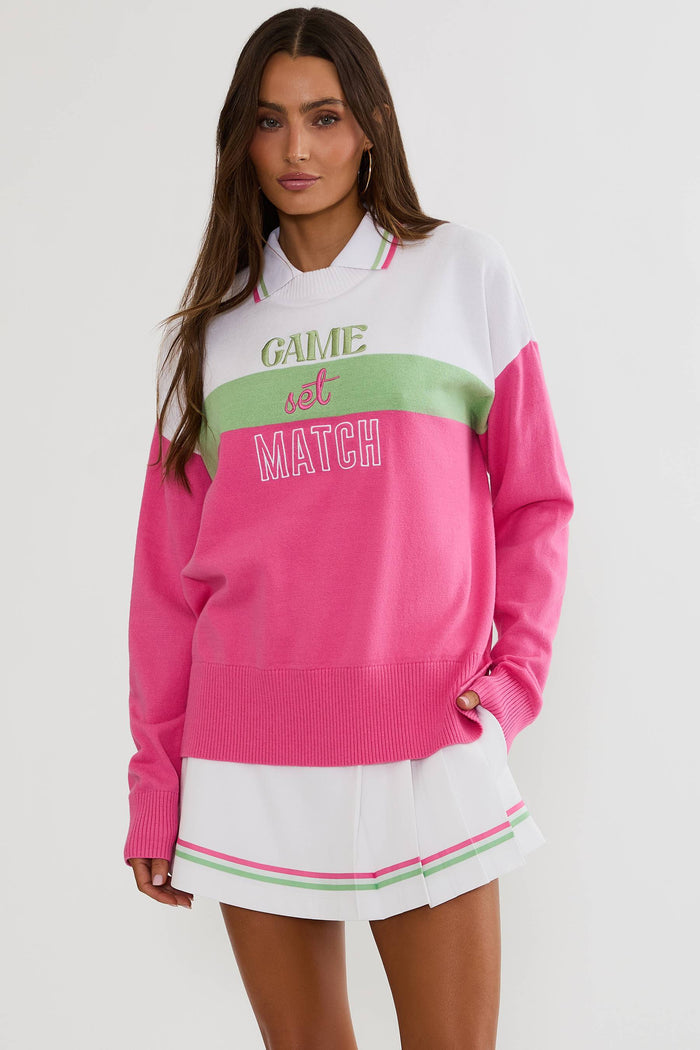 Woman wearing a colorful sweater with 'Game Set Match' text on a white background