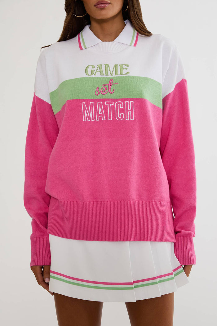 Person wearing a colorful sweater with 'Game Set Match' text on a white background