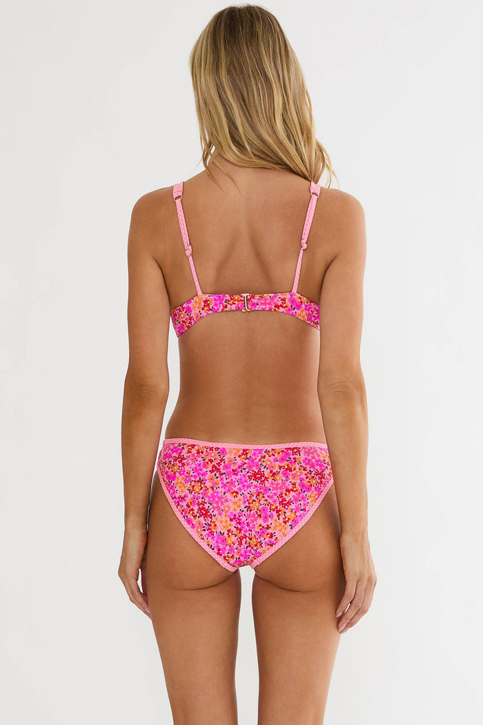 Woman wearing a pink floral bikini against a white background