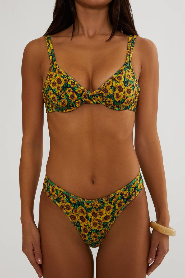 Woman wearing a sunflower-patterned bikini on a white background