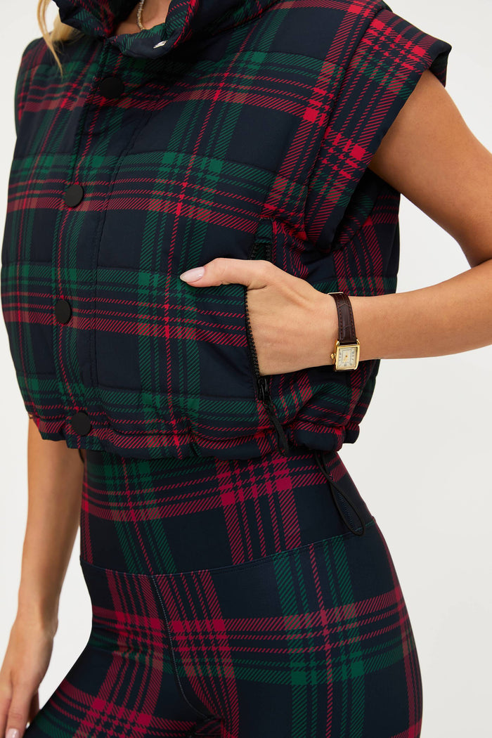 Plaid puffer vest worn by a person on a white background
