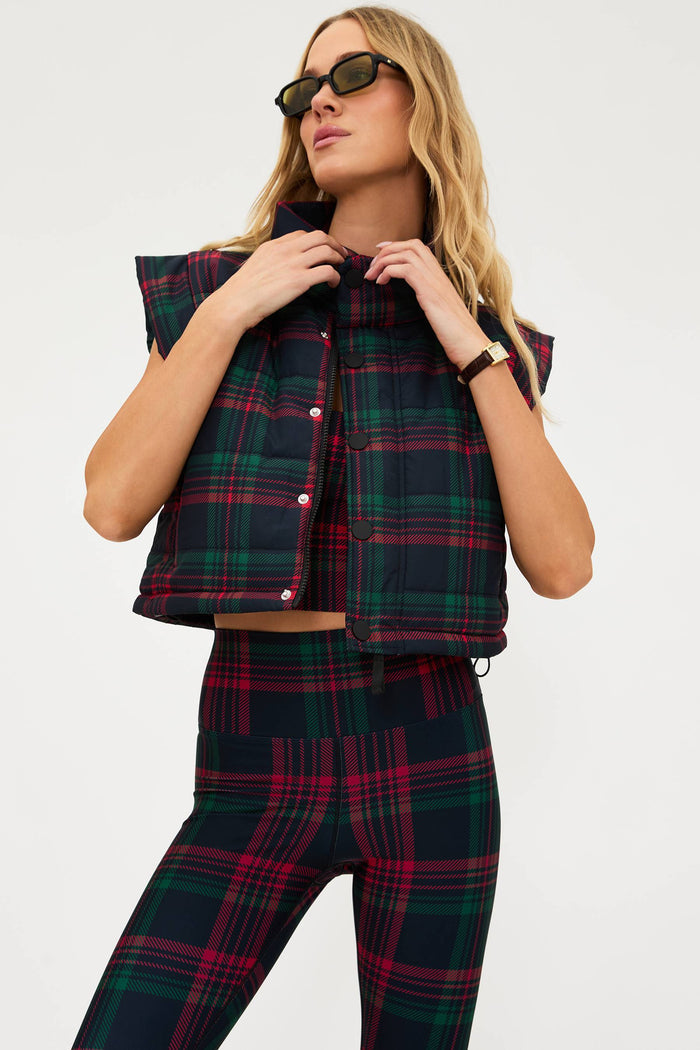Woman wearing a plaid outfit with a vest and pants on a white background
